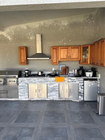 a view of kitchen with stainless steel appliances granite countertop a stove a sink a refrigerator and white cabinets