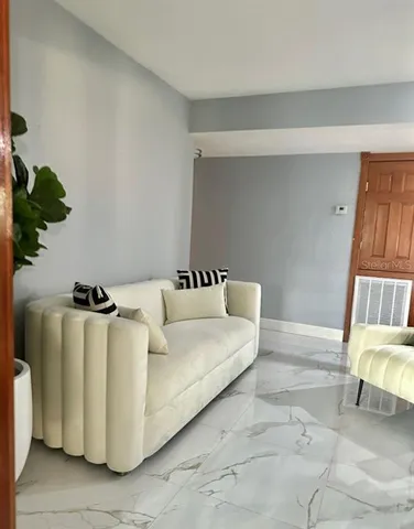 a living room with a couch and a potted plant