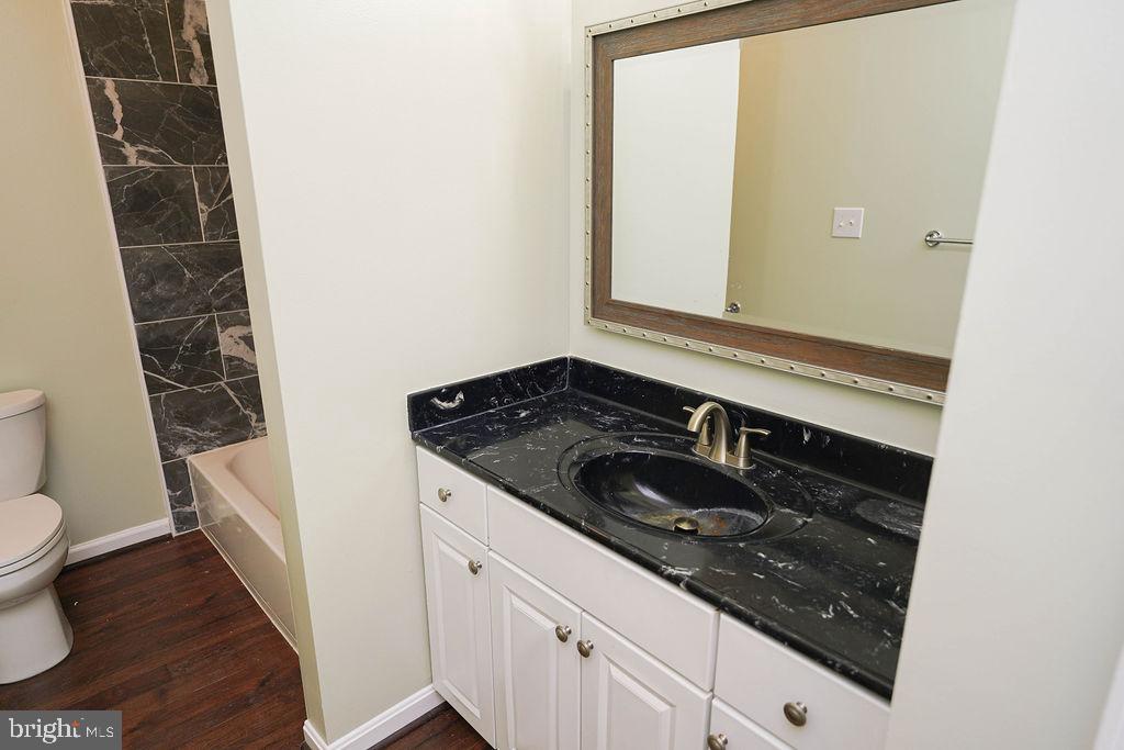 30980 Rehobeth Road Westover, MD 21871 - Photo 21 of 36 a bathroom with a granite countertop sink and a toilet