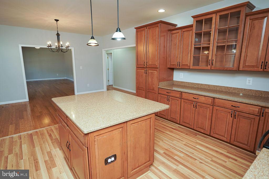 30980 Rehobeth Road Westover, MD 21871 - Photo 10 of 36 a kitchen with stainless steel appliances granite countertop a refrigerator a sink dishwasher a microwave oven a dining table and chairs with wooden floor