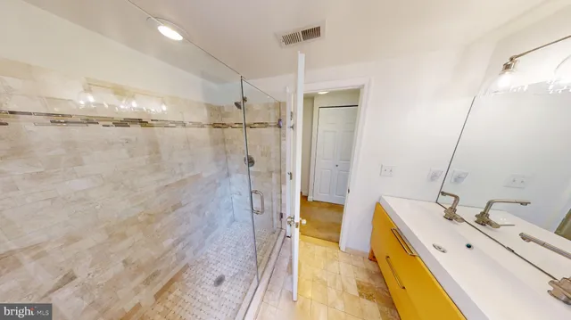 a bathroom with a tub sink vanity and mirror
