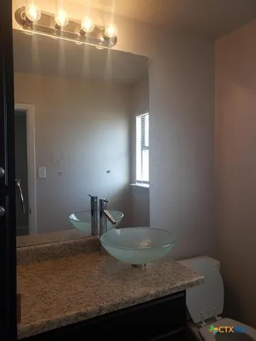 a bathroom with a granite countertop sink and toilet