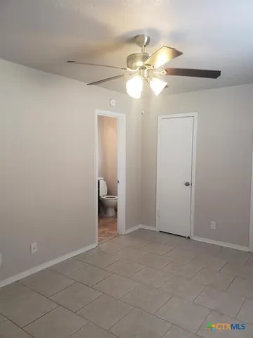 a view of a livingroom with a ceiling fan and lamp