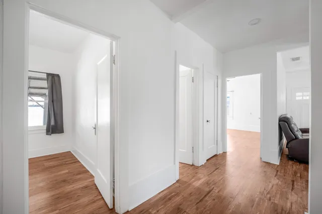 a view of a hallway with wooden floor and chair