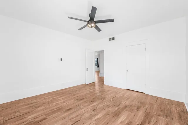 a view of a room with wooden floor and ceiling fan