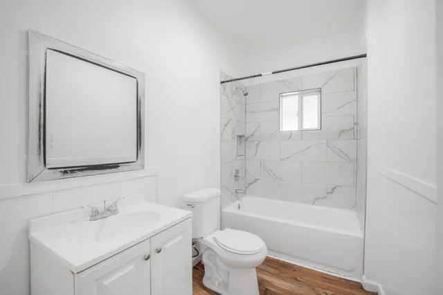 a bathroom with a bathtub shower sink vanity and toilet