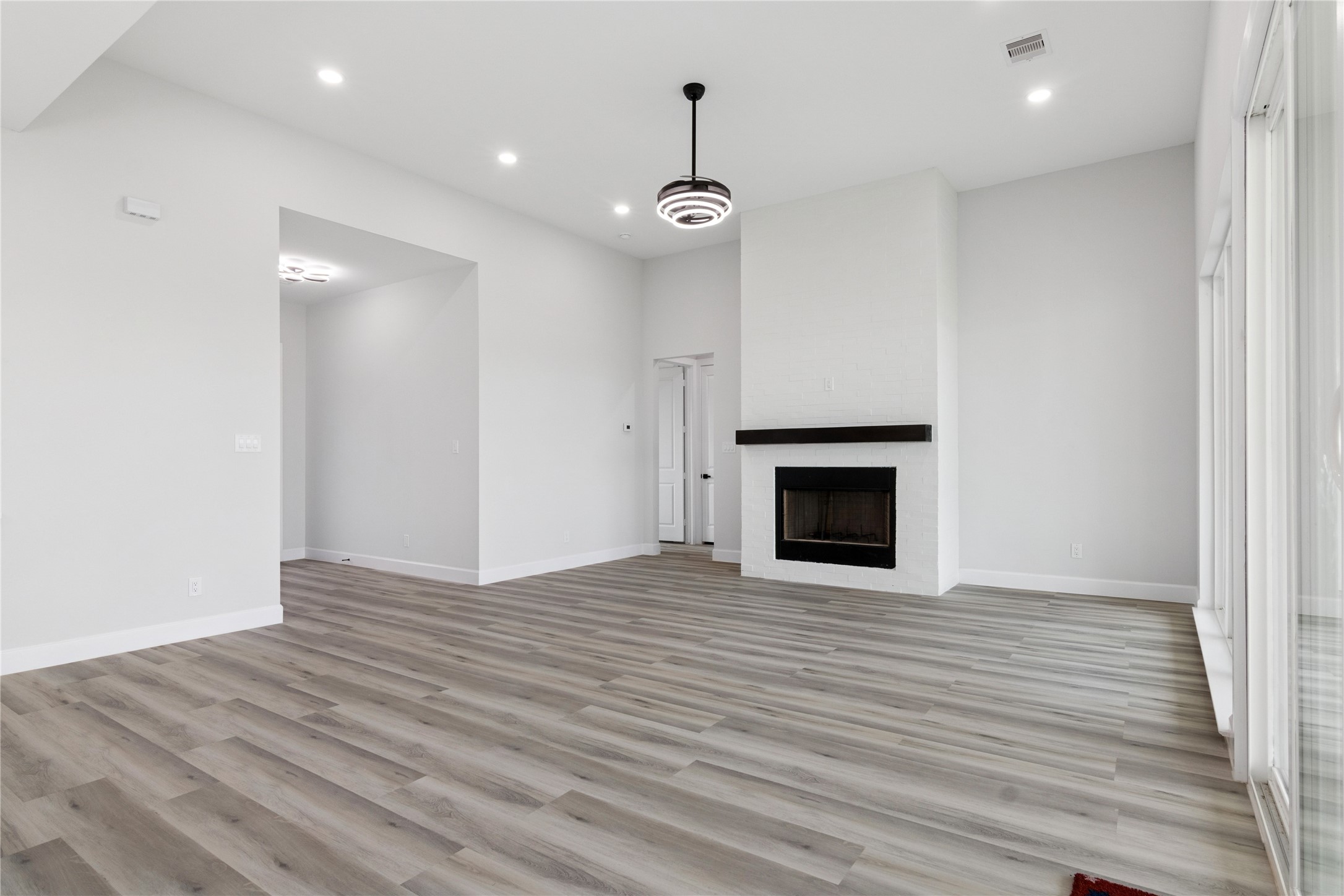 5766 Ward Bend Road Sealy, TX 77474 - Photo 9 of 45 a view of an empty room with wooden floor fireplace and a window