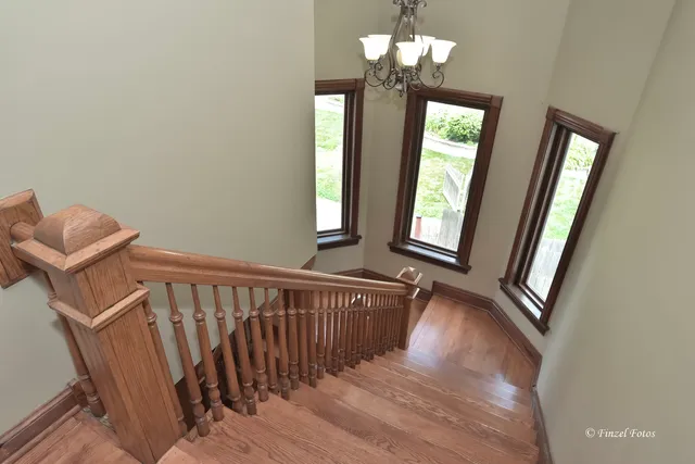 a view of a hallway with windows and chandelier