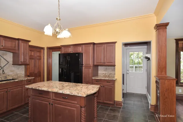 a kitchen with kitchen island granite countertop stainless steel appliances a counter space and cabinets