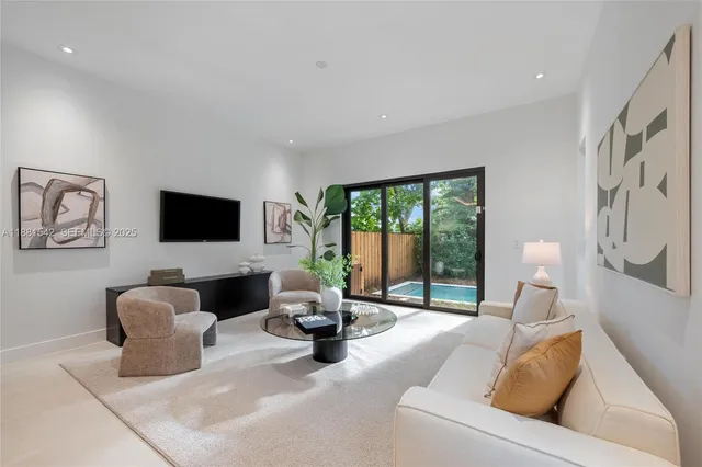 a living room with furniture a flat screen tv and a potted plant