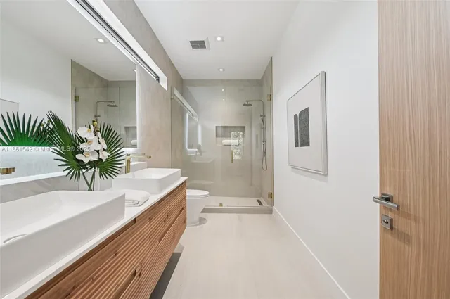 a bathroom with a sink a toilet and shower