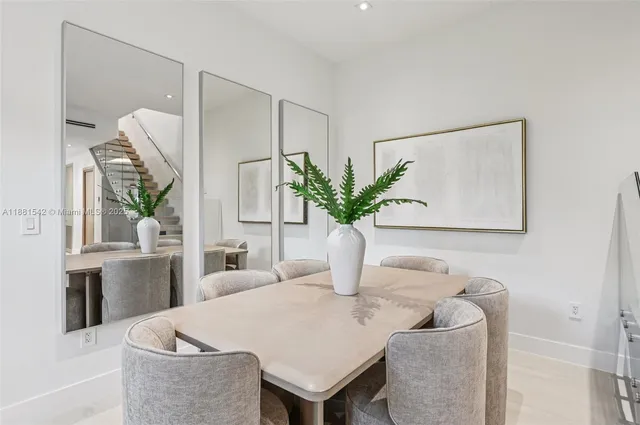 a dining room with furniture and a potted plant
