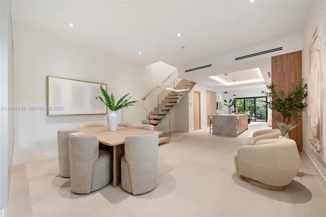 a living room with furniture a potted plant and a chandelier