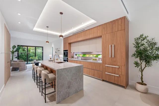 a kitchen with kitchen island granite countertop a sink a counter top space and living room view