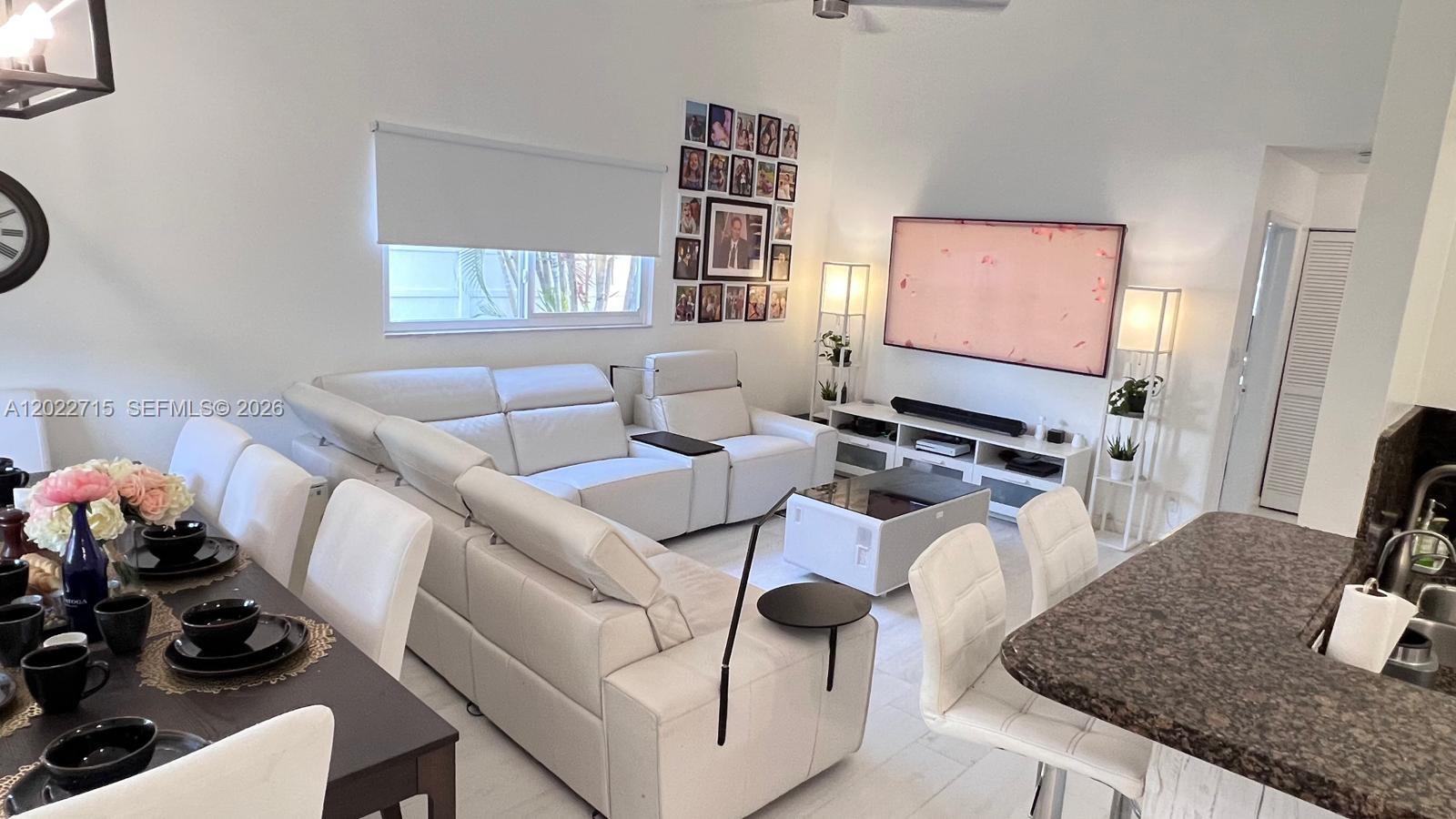 10669 Boca Entrada Boulevard Boca Raton, FL 33428 - Photo 3 of 19 a living room with furniture a flat screen tv and a window