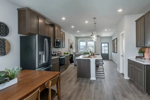 a kitchen with a sink a counter space appliances and cabinets