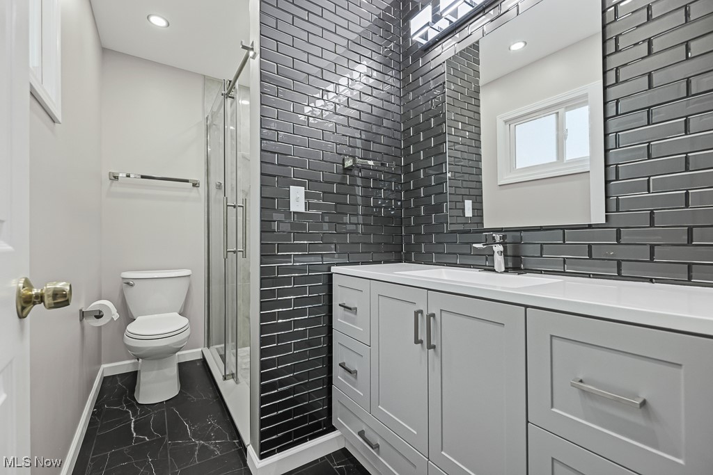17682 Drake Road Strongsville, OH 44136 - Photo 21 of 45 Bathroom with marble look tiles, a shower stall, vanity, recessed lighting, and decorative backsplash