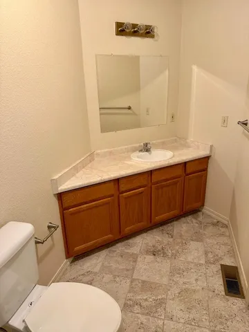 a bathroom with a toilet a sink and mirror