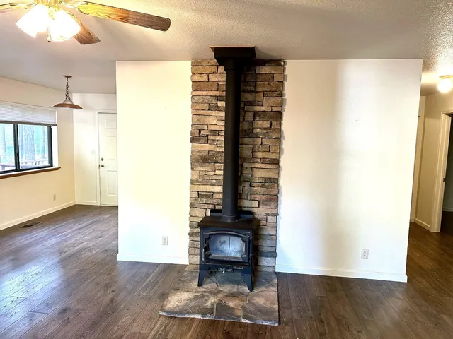 a view of a hallway with wooden floor and a bathroom