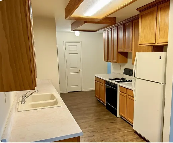 a kitchen with a stove a sink and a refrigerator