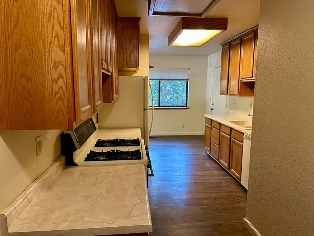 a kitchen with granite countertop wooden cabinets and stainless steel appliances