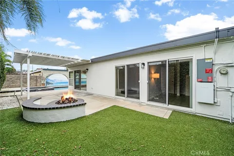 a view of a house with backyard and sitting area