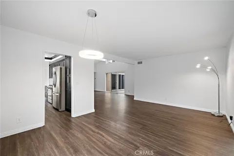 a view of a room with wooden floor and a ceiling fan
