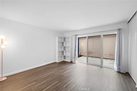 an empty room with wooden floor and sliding door