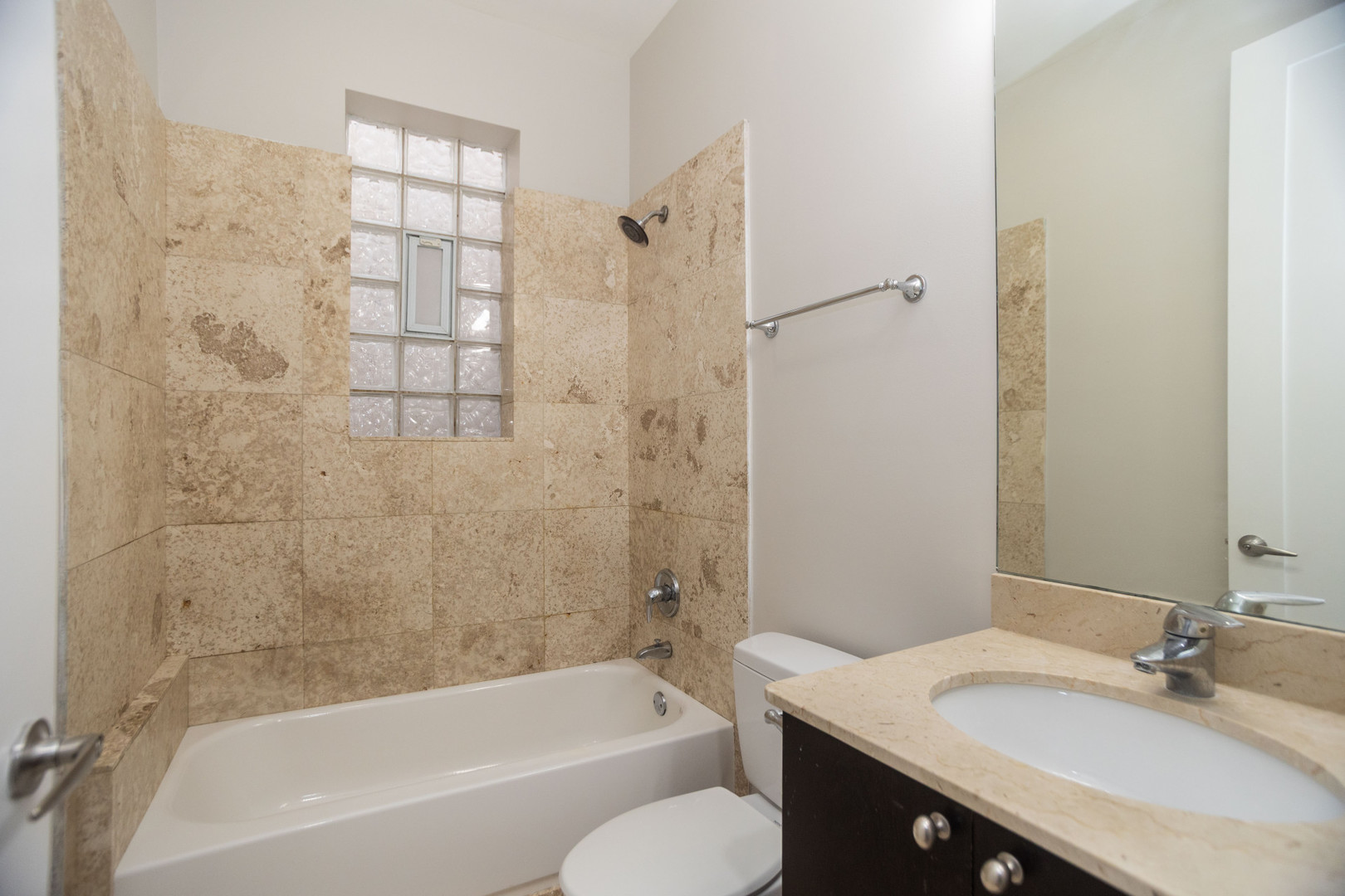 2444 West Madison Street, Unit 3 Chicago, IL 60612 - Photo 13 of 14 a bathroom with a granite countertop bathtub shower sink vanity and toilet