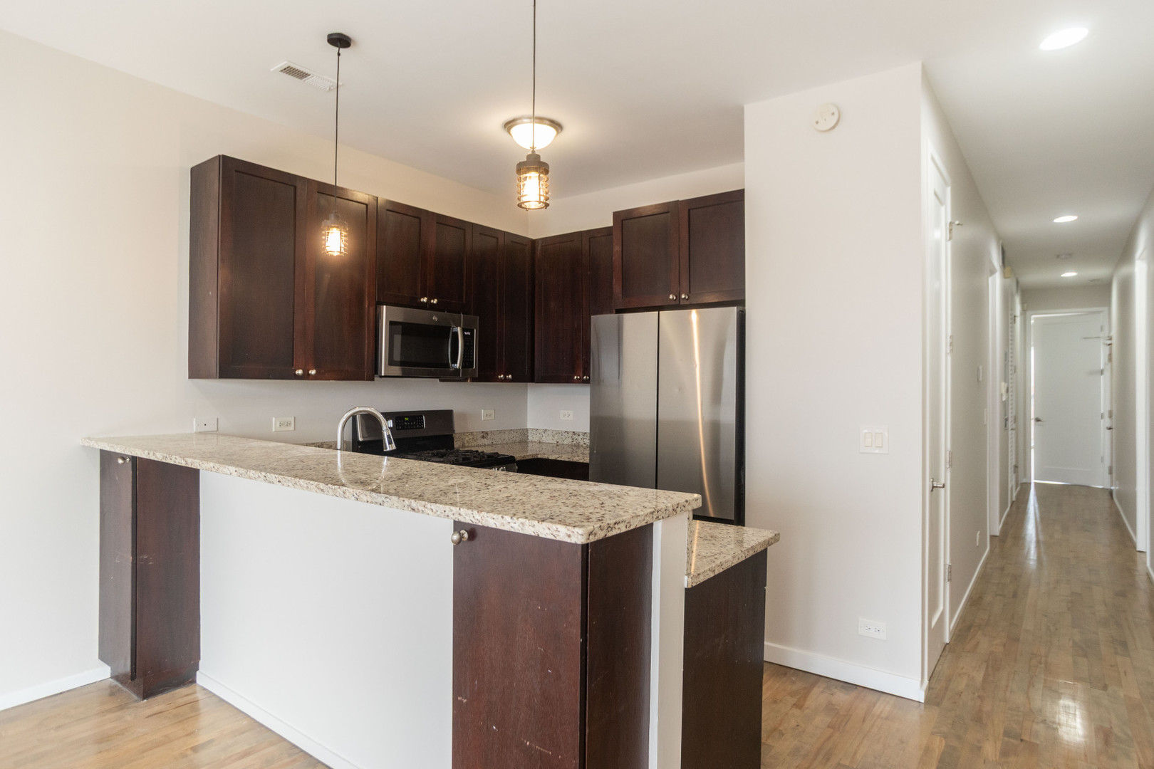 2444 West Madison Street, Unit 3 Chicago, IL 60612 - Photo 6 of 14 a kitchen with kitchen island a counter space a sink and refrigerator