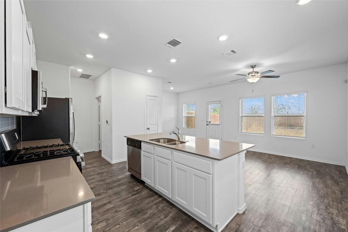 15216 Spruce Frost Cove, Unit B Del Valle, TX 78617 - Photo 3 of 21 a kitchen with counter top space a sink stainless steel appliances and windows