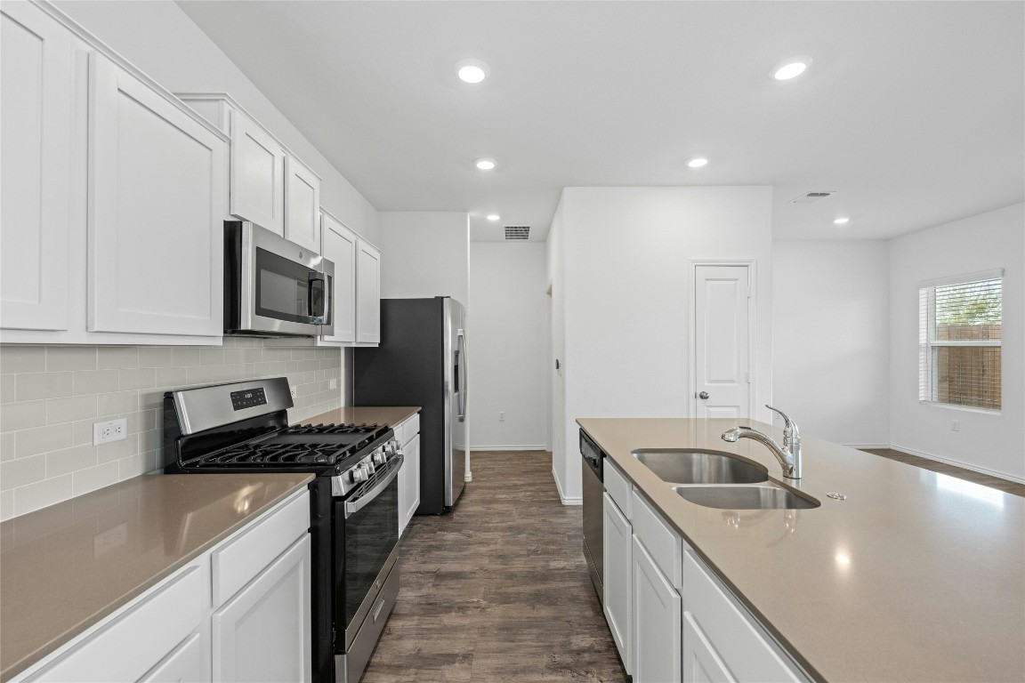 15216 Spruce Frost Cove, Unit B Del Valle, TX 78617 - Photo 4 of 21 a kitchen that has a sink a stove and refrigerator