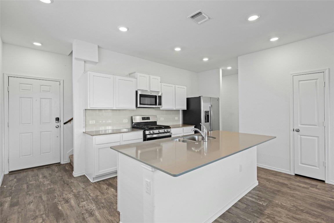 15216 Spruce Frost Cove, Unit B Del Valle, TX 78617 - Photo 5 of 21 a kitchen with stainless steel appliances a sink stove and refrigerator