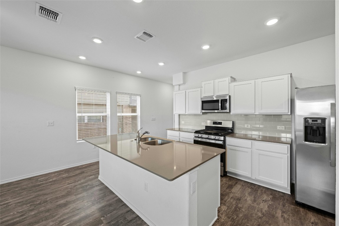 15216 Spruce Frost Cove, Unit B Del Valle, TX 78617 - Photo 7 of 21 a kitchen with granite countertop stainless steel appliances and wooden cabinets