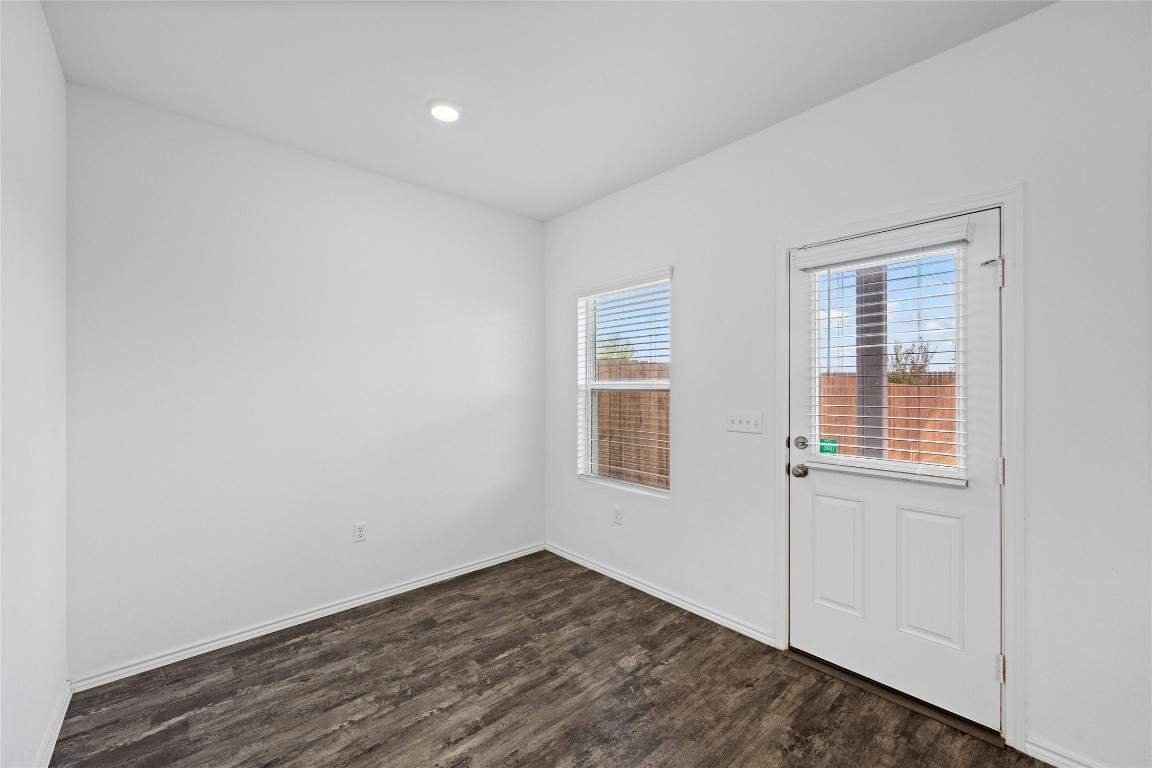 15216 Spruce Frost Cove, Unit B Del Valle, TX 78617 - Photo 9 of 21 a view of an empty room with wooden floor and a window
