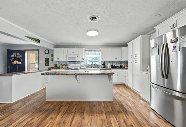 a kitchen with a refrigerator and white cabinets