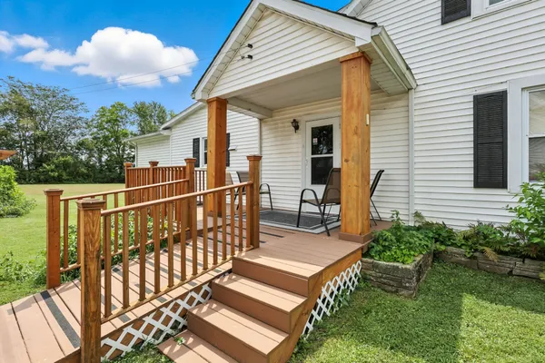 a view of a house with wooden deck and furniture