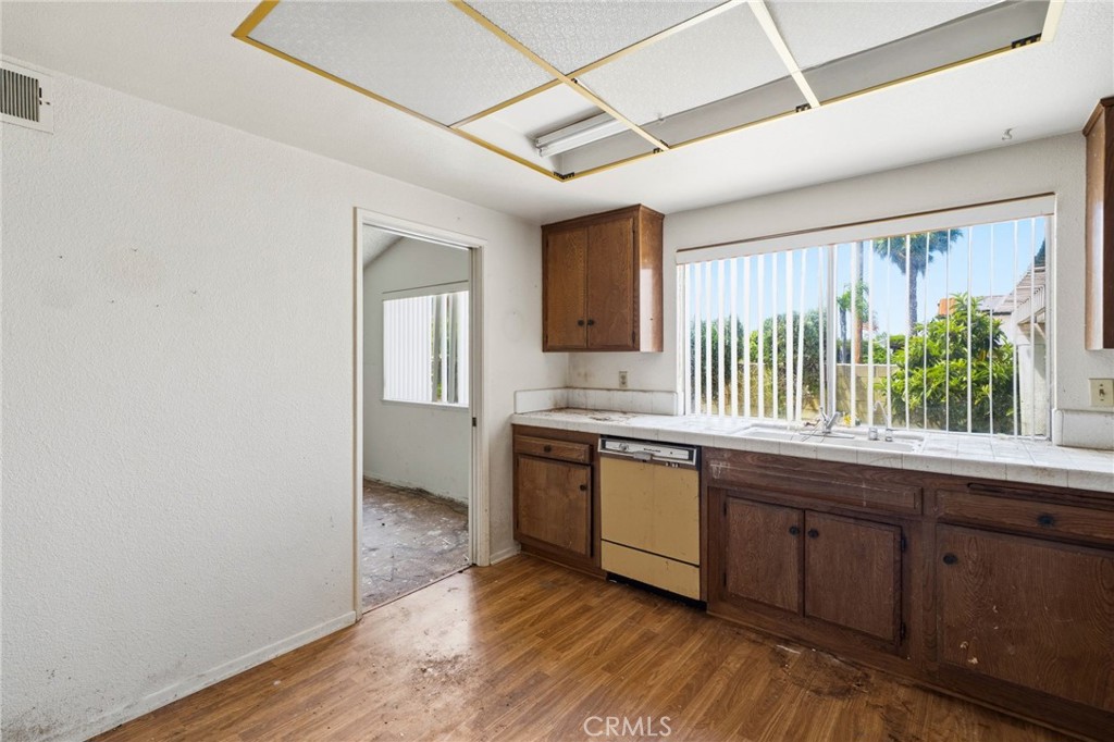 5131 Rotherham Circle Westminster, CA 92683 - Photo 20 of 50 a large kitchen with granite countertop a sink window and wooden floor