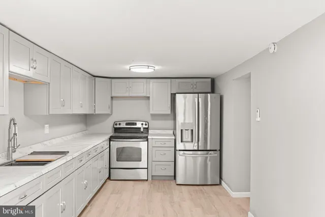 a kitchen with a stove a refrigerator and a sink