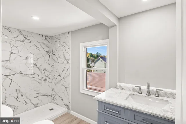 a bathroom with a granite countertop sink a vanity and a shower