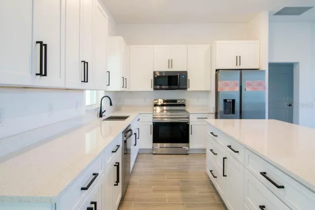 a kitchen with granite countertop a sink stove and refrigerator