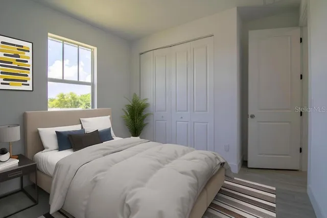 a bedroom with a large bed and wooden floor