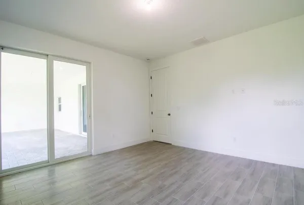 an empty room with wooden floor and sliding door