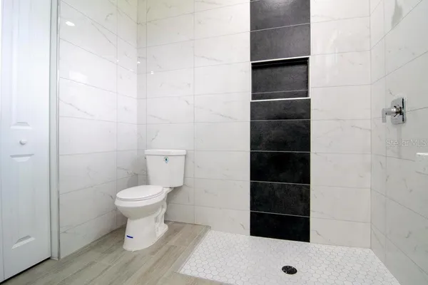 a bathroom with a toilet and a shower