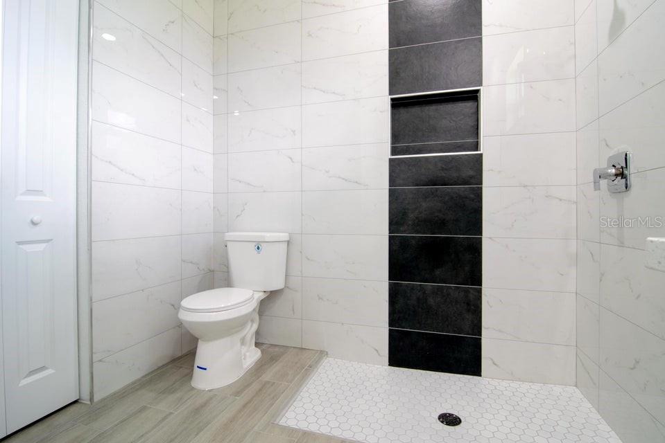 10654 Washington Road Port Charlotte, FL 33981 - Photo 19 of 35 a bathroom with a toilet and a shower