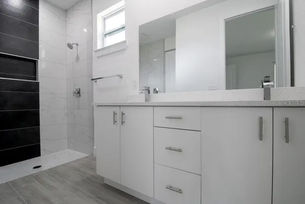a bathroom with a granite countertop sink and a mirror