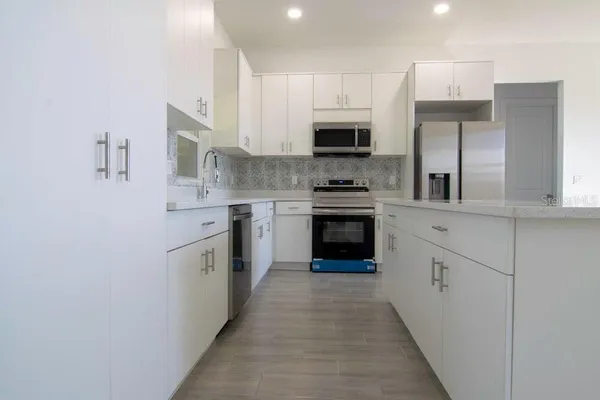 a kitchen with cabinets stainless steel appliances and sink