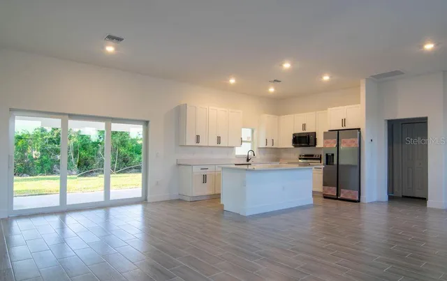 a kitchen with stainless steel appliances granite countertop a refrigerator and a stove top oven