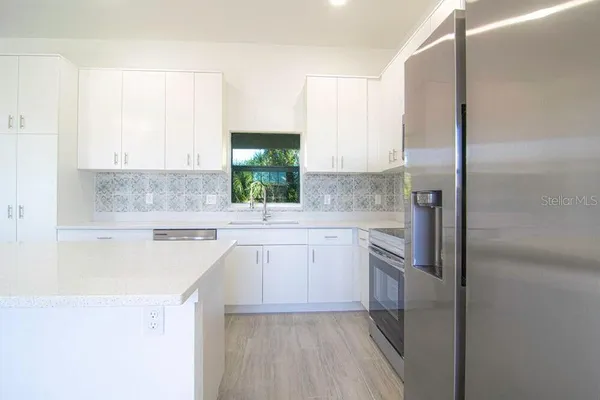 a kitchen with a sink stove and refrigerator