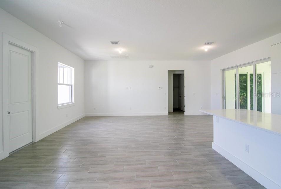 10654 Washington Road Port Charlotte, FL 33981 - Photo 9 of 35 an empty room with wooden floor and windows
